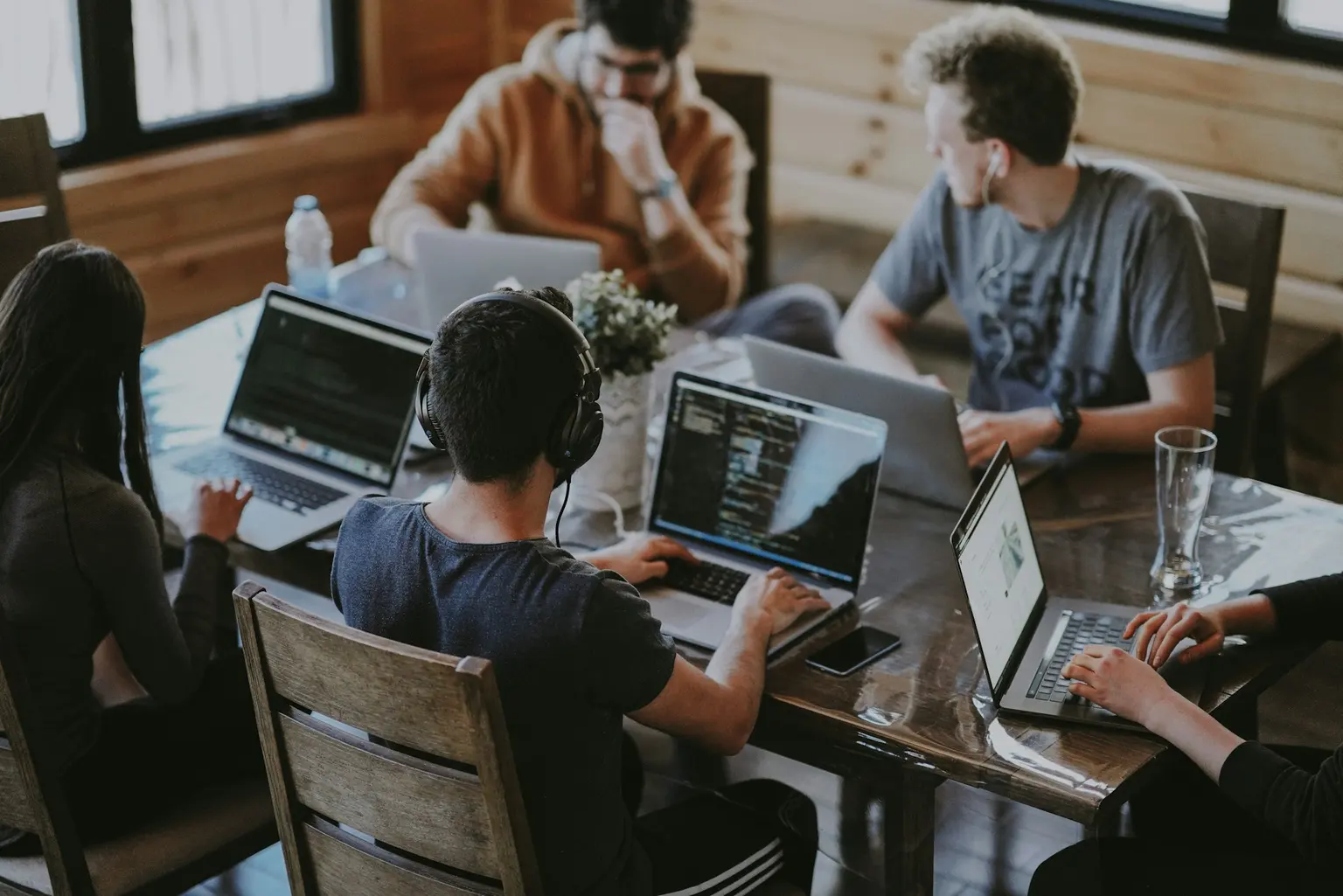 Stock photograph of a collaborative team working together around laptops